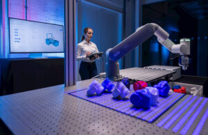 A woman with a tablet controlling an ABB cobot.