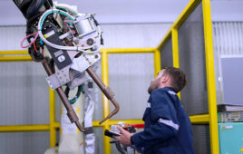 An EY engineer checking a robot at a workshop.